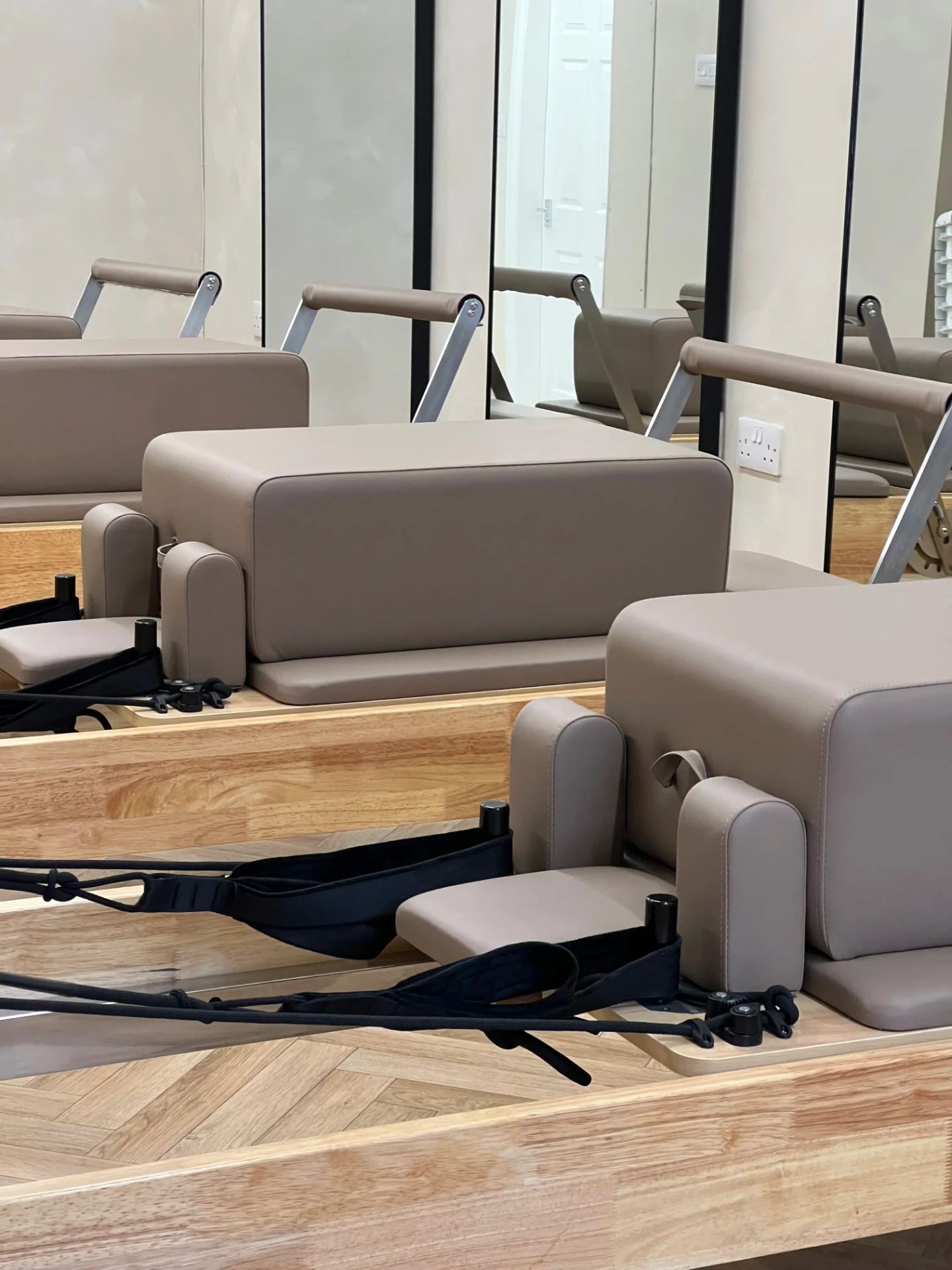 Close view of reformer boxes and shoulder rests in taupe leather